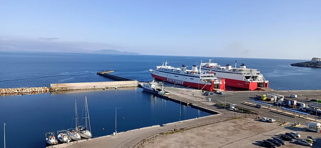 Rafina port seen from above — ferries at the quay, sailboats and the breakwater