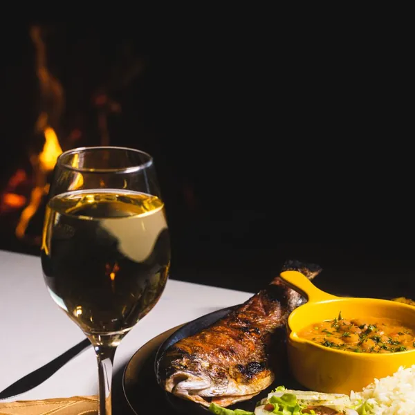 Grilled whole fish served with white wine at a seaside taverna